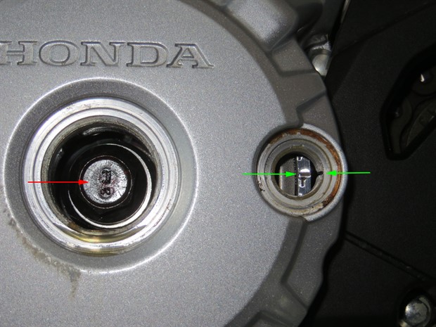 Aligning T mark on flywheel (green arrows). Crankshaft bolt (red arrow).