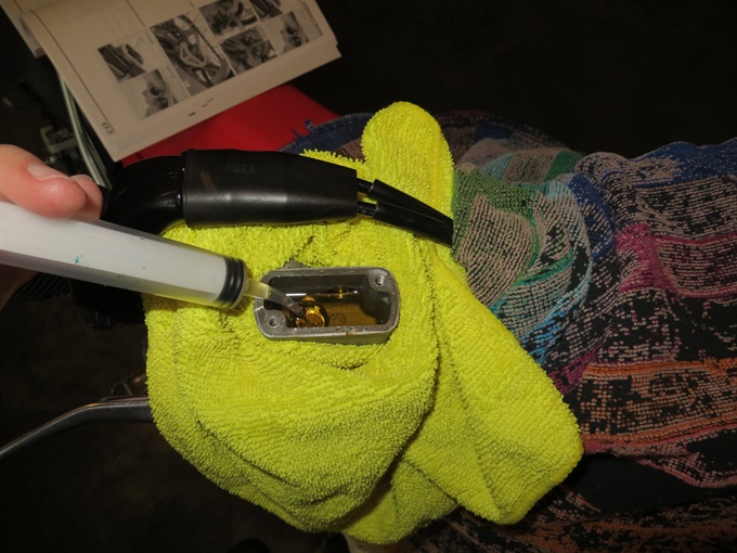 CRF250F - removing old brake fluid from the front master cylinder with a syringe.